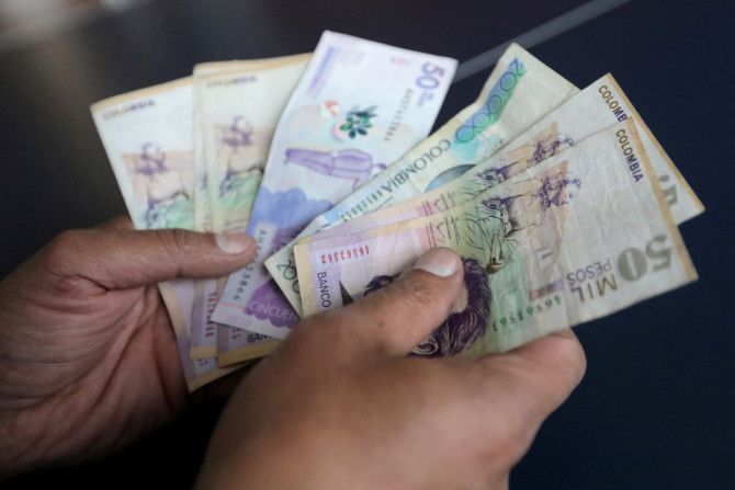 Mitarbeiter zählt kolumbianische Pesos in einem Geschäft in Bogota