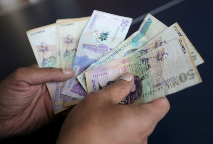 Mitarbeiter zählt kolumbianische Pesos in einem Geschäft in Bogota
