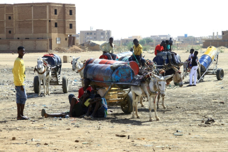 Menschen füllen am 22. April 2023 im Süden von Khartum Fässer mit Wasser, inmitten von Wasserknappheit, die durch anhaltende Kämpfe zwischen den Streitkräften zweier rivalisierender sudanesischer Generale verursacht wird