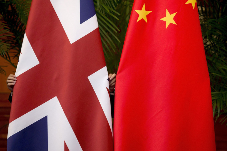 Ein Arbeiter passt britische und chinesische Nationalflaggen an, die für eine Unterzeichnungszeremonie beim siebten britisch-chinesischen Wirtschafts- und Finanzdialog „Roundtable on Public-Private Partnerships“ in Peking ausgestellt sind