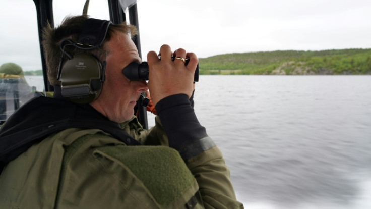 Der norwegische Sergeant Lars Erik Gausen scannt mit seinem Fernglas die russische Grenze, während er am Fluss Pasvik patrouilliert