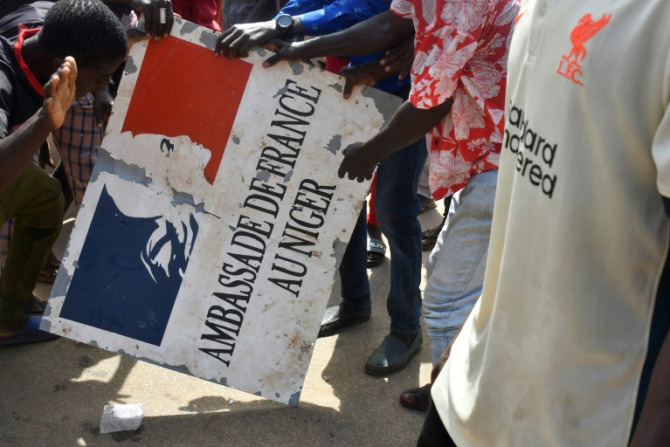 Pro-Junta-Demonstranten halten am Sonntag ein Schild aus der französischen Botschaft in Niamey hoch