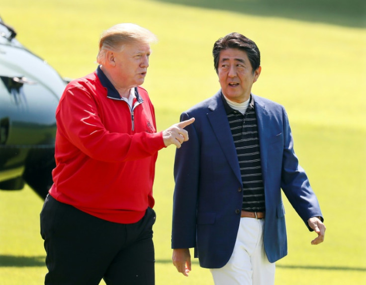 Japans damaliger Premierminister Shinzo Abe hört dem damaligen US-Präsidenten Donald Trump zu, bevor sie am 26. Mai 2019 in Chiba, Japan, Golf spielen